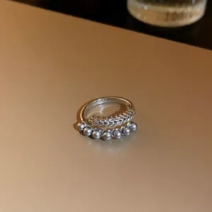 Vue détaillée d'une bague réglable en argent avec des perles grises et une texture d'épi