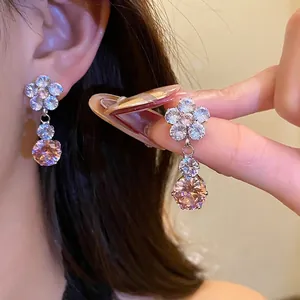 Elegant zircon flower drop earrings with a sparkling pink main stone, perfect for party wear.