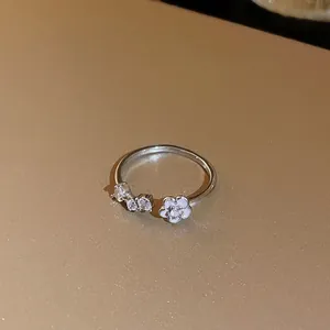 Gros plan d'une bague ouverte élégante en argent avec fleur et pierres de zircon