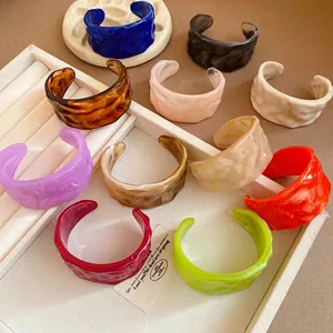 Set of colorful marbled resin cuff bracelets with pleated texture and open design