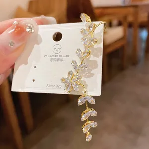 Detailed macro view of a gold-plated floral ear cuff featuring marquise-cut zircons