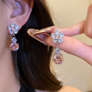 Detailed macro view of elegant zircon flower drop earrings with champagne pink gemstones