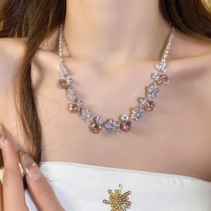 Close-up of elegant flower necklace featuring sparkling pink zirconia on model's neck.