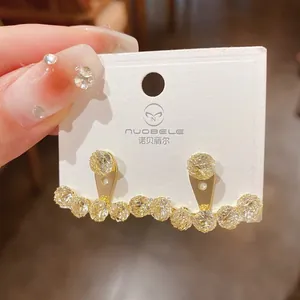 Detailed view of gold-plated earrings with sparkling cubic zirconia on a display card