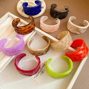 Detailed view of colorful marbled resin open cuff bracelets with unique textured finish