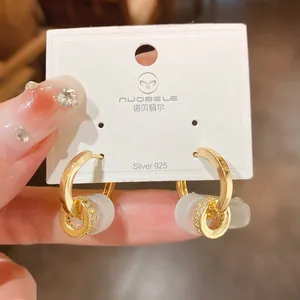 Detailed view of elegant gold-plated hoop earrings with zircon accents on display card