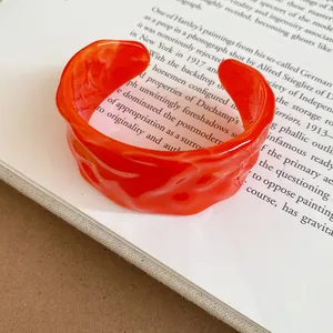 Detailed view of the orange marbled texture on this stylish wrinkled open cuff bracelet.