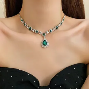 Close-up of elegant emerald water-drop pendant necklace on model