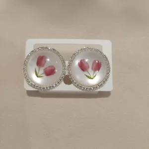 Close-up view of elegant tulip flower stud earrings featuring a sparkling zirconia halo