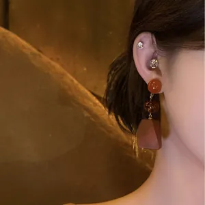 Retro ethnic style wooden bead drop earrings shown on model with warm lighting