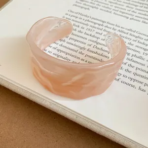 Close-up of a marbled resin open cuff bracelet with a unique rippled texture design.