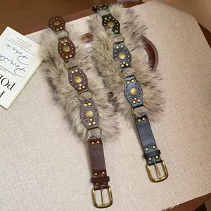 Detailed view of vintage leather belts featuring faux fur trim and gold rivet accents.