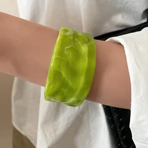 Close-up detail of a minimalist green smudged resin bracelet with folded texture design
