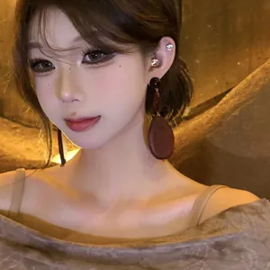 Vintage oval dark wood bead drop earrings shown on an Asian female model for a chic look