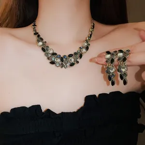 Vue détaillée d'un ensemble collier et boucles d'oreilles pompons en cristal noir