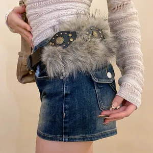 Close-up of a retro leather rivet belt featuring fluffy faux fur trim on a denim skirt