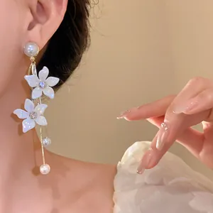 Detailaufnahme eleganter Blumentraum-Ohrringe mit Perlen und Kristallen am Ohr