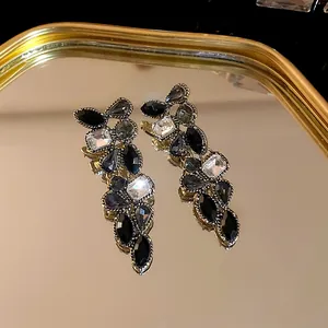 Gros plan de boucles d'oreilles vintage à pampilles avec cristaux noirs et transparents