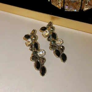Gros plan de boucles d'oreilles pendantes vintage avec cristaux noirs et transparents