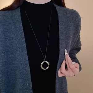 Sautoir minimaliste en cordon noir avec un grand pendentif anneau circulaire argenté