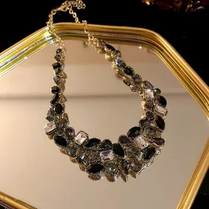 Vue détaillée d'un collier plastron orné de cristaux noirs et transparents sur métal doré