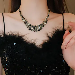 Gros plan d'un collier imposant avec des pierres vert foncé sur un mannequin