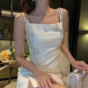 Dettaglio di un'elegante spilla a farfalla con strass su un abito da sera bianco chic