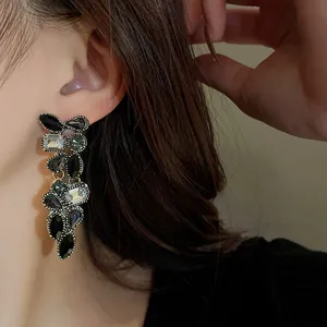 Gros plan de boucles d'oreilles vintage à aiguille d'argent avec strass gouttes noires