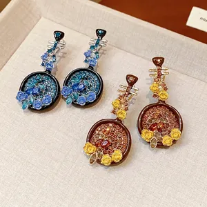 Vintage Pipa earrings with sparkling rhinestones and floral designs in blue and yellow.