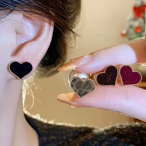 Close-up of heart-shaped flocked earrings with gold beaded edges in multiple colors