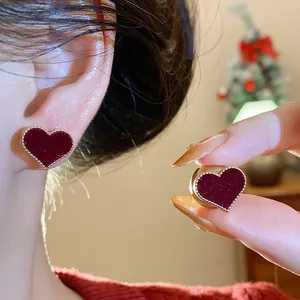 Close-up of red flocked heart-shaped earrings with gold beaded edges for autumn winter