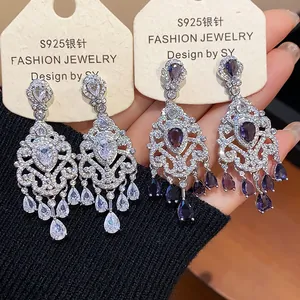 Detailed macro view showing intricate retro chandelier earrings with purple and clear zircons
