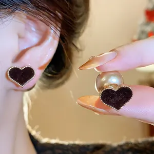Detailed view of stylish velvet heart-shaped earrings with pearl backs for winter fashion.