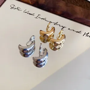 Gros plan détaillé montrant la texture des boucles d'oreilles clips gouttes minimalistes