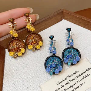 Detail macro view of vintage Chinese lute-shaped earrings with crystals and floral enamel.