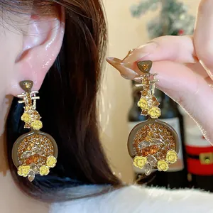 Detailed macro view of vintage Pipa-shaped drop earrings with amber crystals and yellow flowers