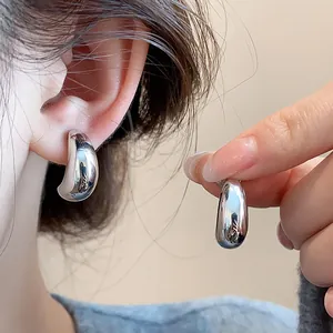 Gros plan détaillé de boucles d'oreilles clips ovales minimalistes en métal argenté