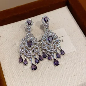 Close-up of vintage French court style silver earrings with purple zircon drops detail