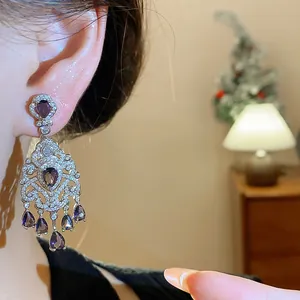 Close-up of elegant French vintage court style silver earrings with purple zircon drops