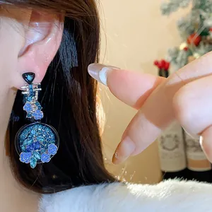 Detailed view of elegant vintage blue rhinestone flower pipa earrings worn on ear