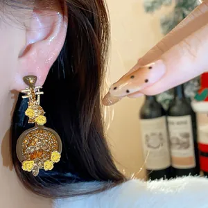 Detailed macro view of a vintage Pipa-shaped earring with rhinestones and yellow flowers.
