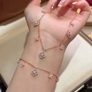 Close-up detail of rose gold bracelet featuring zircon and pink mother-of-pearl flower charms