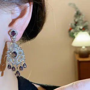 Macro view of vintage French court style silver teardrop earrings with purple zircons