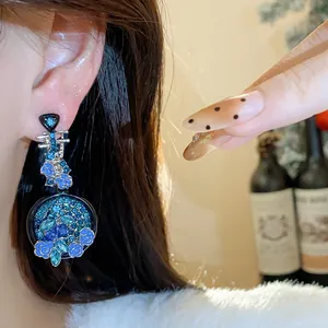 Close-up view of blue rhinestone lute earrings with elegant floral details on ear