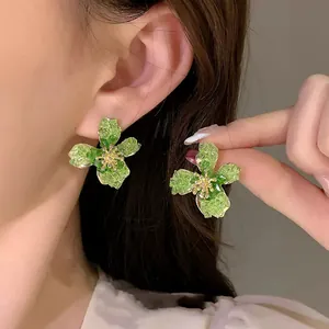 Elegant green flower stud earrings for women with textured petals and silver needle backings.