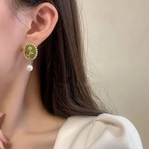 Elegant green flower stud earrings with pearl drop for women in Korean style.