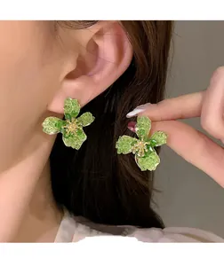 Close-up view of elegant green flower earrings with a unique textured glass effect