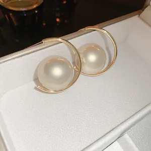 Detailed view of elegant gold-plated hoop earrings featuring large oval iridescent pearls