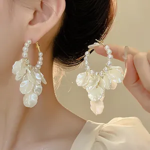 Detailed close-up of elegant French vintage hoop earrings with pearls and shell petals