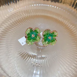 Detailed macro view of forest-style green crystal flower earrings with S925 silver needles.